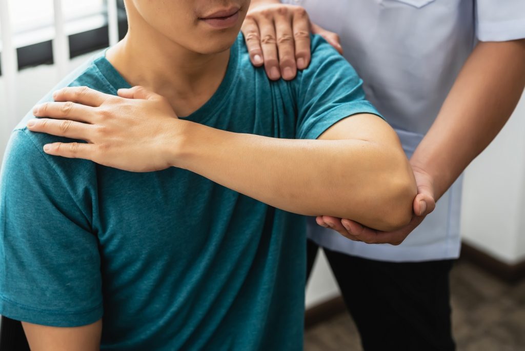 Close-up of a physiotherapist stretching to a man patient at the clinic.
